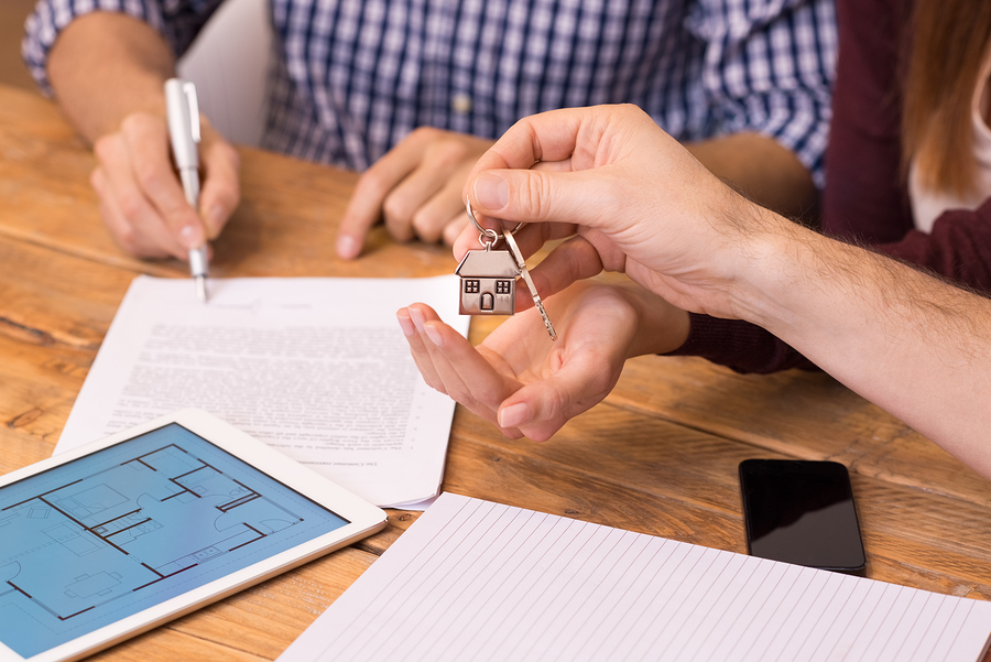 Happy young couple getting keys of their new house