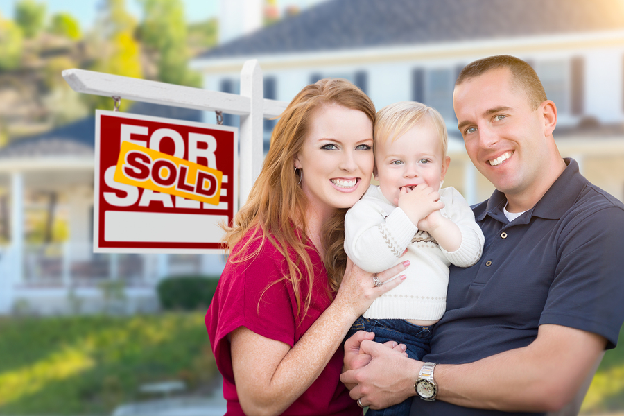 Happy Young Military Family in Front of Sold For Sale Real Estat Clear Lake, Iowa
