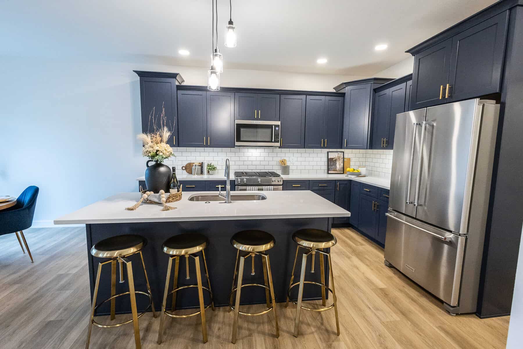 Modern kitchen with navy cabinets and gold bar stools